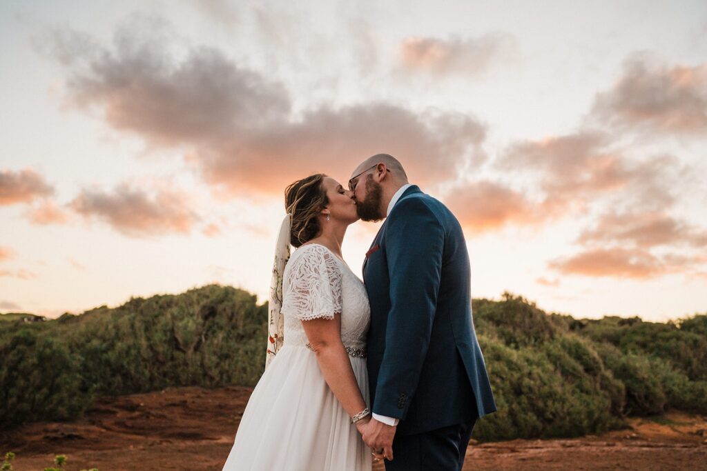 Bride and groom kiss during sunset at their Kauai Hawaii elopement 