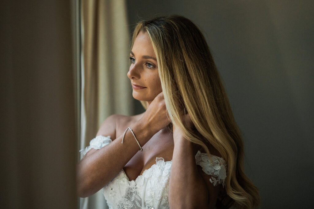 Bride puts on her earrings while getting ready for her elopement first look in Washington