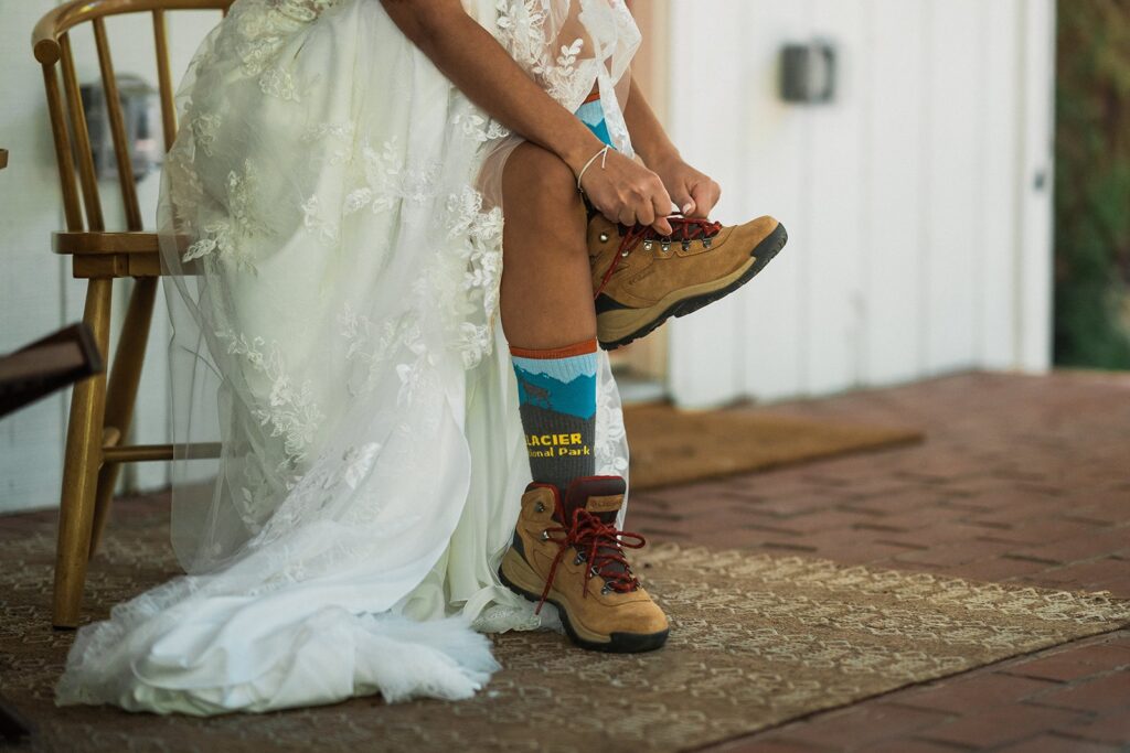 Bride laces up brown hiking boots while getting ready for her Mount Rainier National Park elopement. 