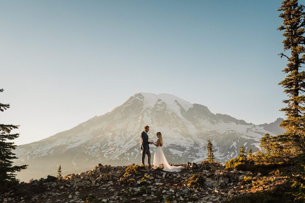 Bride and groom hold hands during their Mount Rainier National Park elopement ceremony