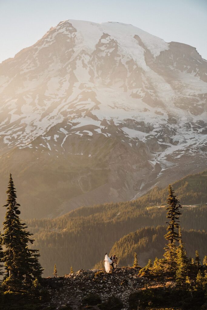 Groom dips bride for a kiss on a trail during their Mt Rainier National Park elopement 