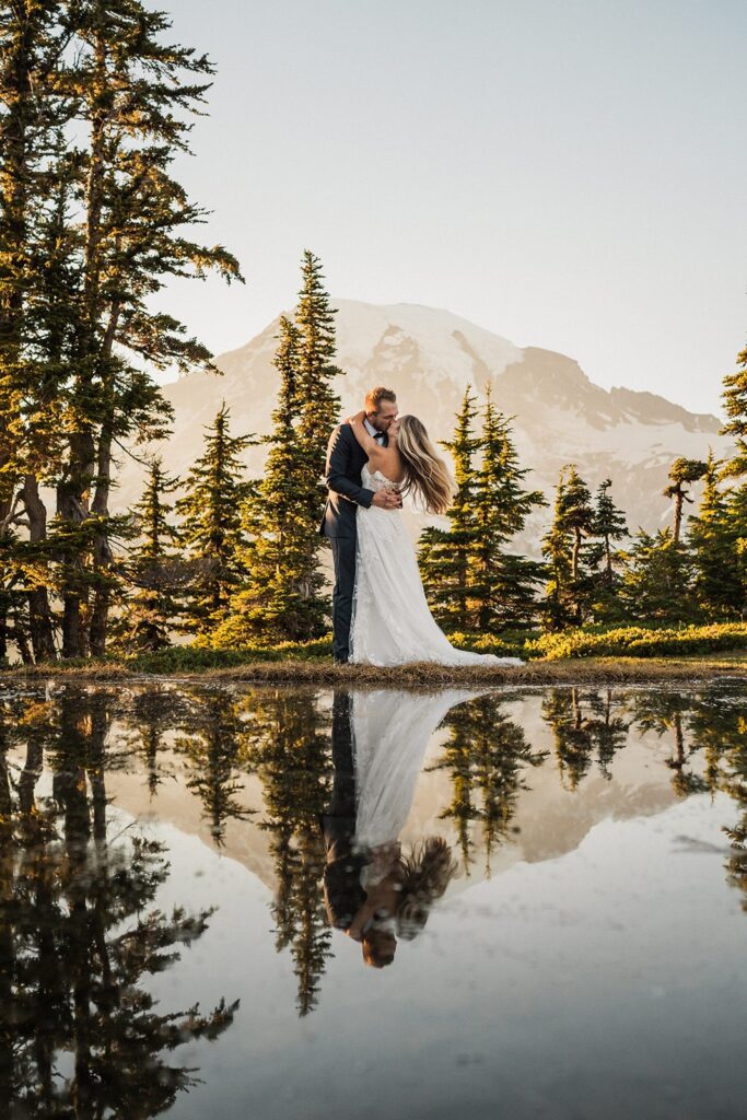 Bride and groom kiss by a tarn at their Mt Rainier elopement 