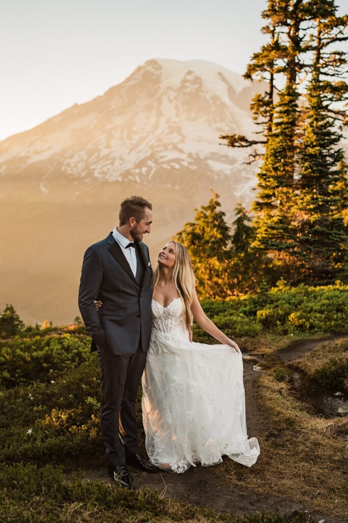 Bride and groom side hug on a mountain trail during their elopement at Mount Rainier National Park 