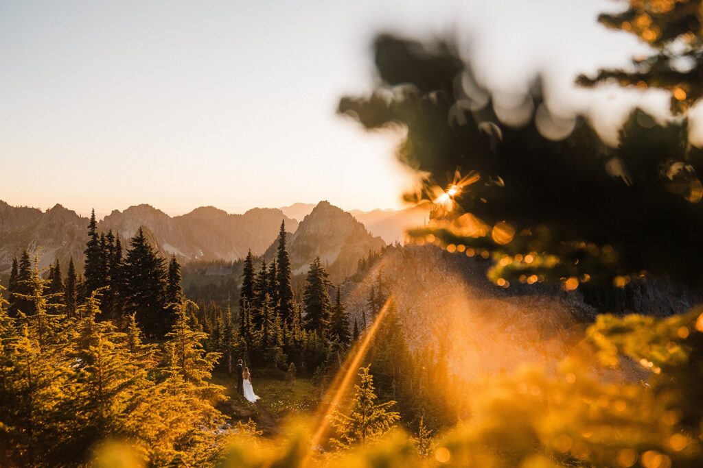 Bride and groom hug on a mountain trail at sunset at Mount Rainier National Park