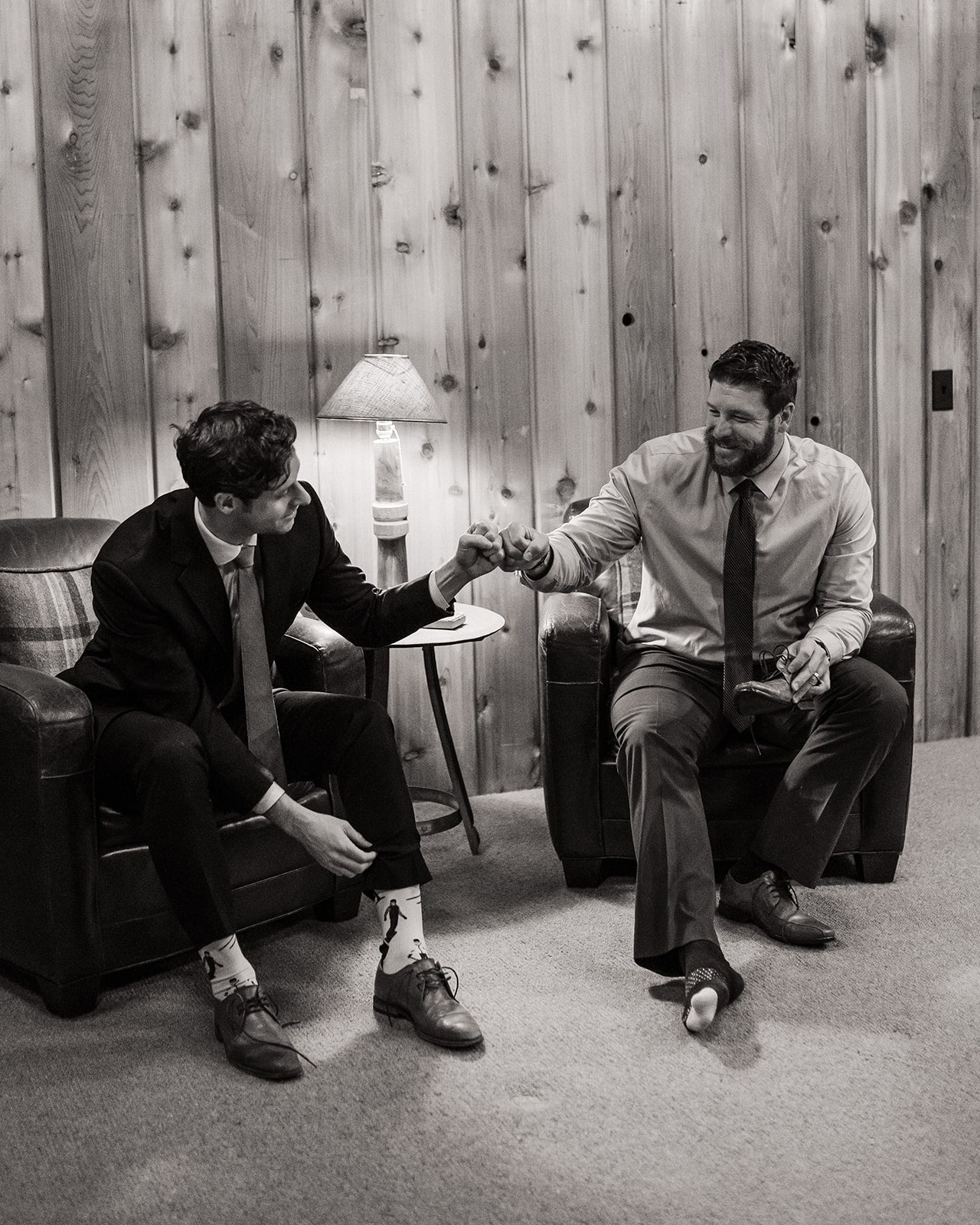 Groom fist bumps a friend while getting ready for his fall wedding in Washington