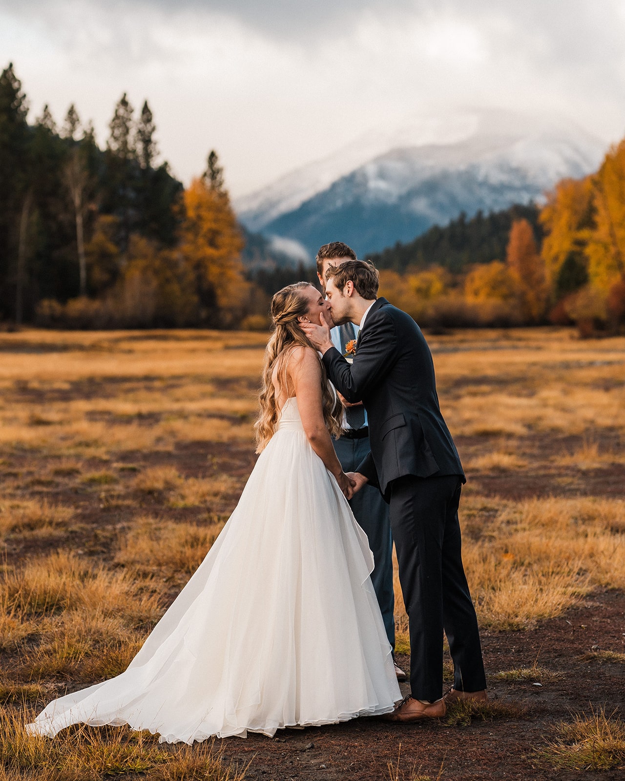 Bride and groom kiss during their outdoor autumn wedding ceremony in Washington