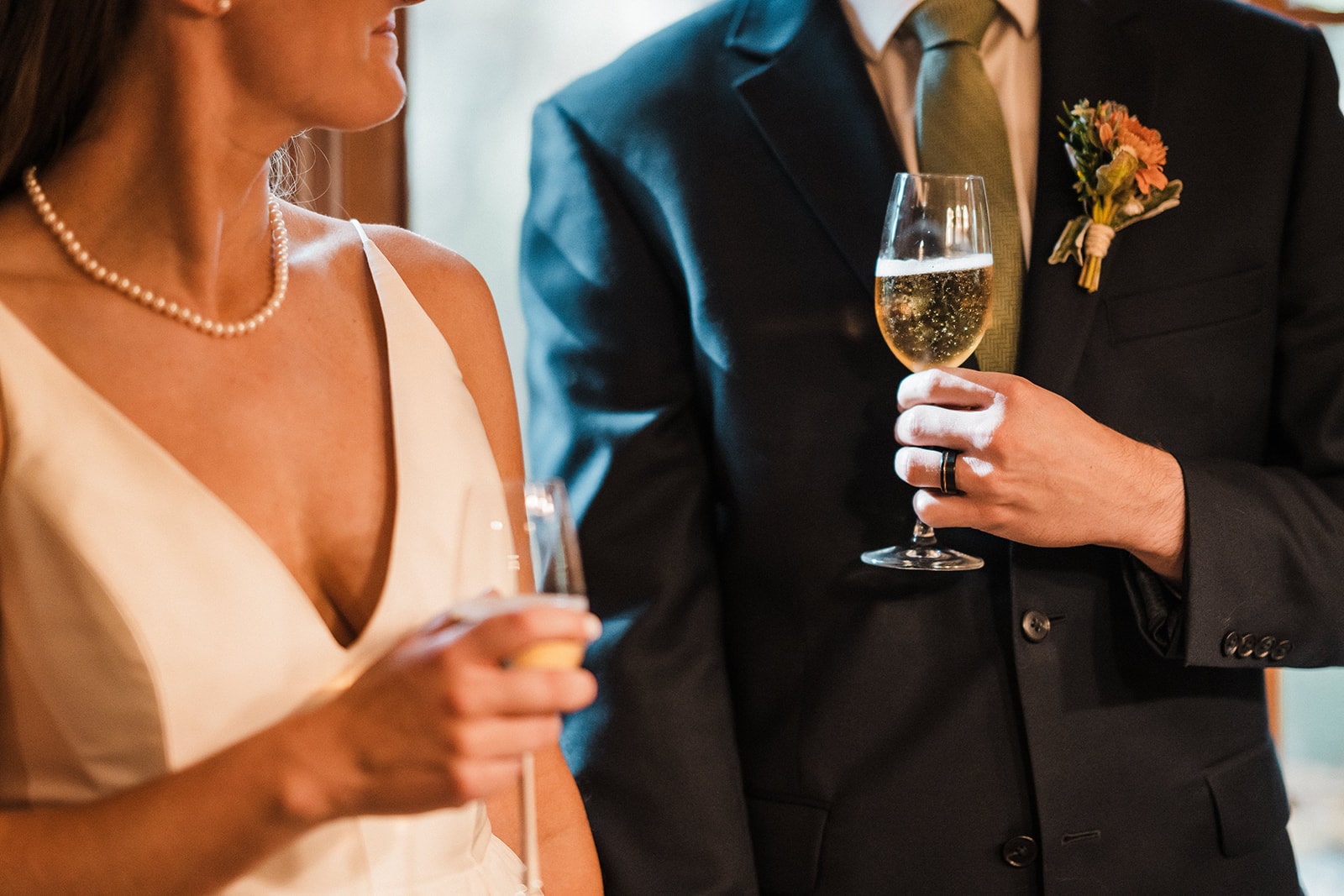 Bride and groom hold champagne glasses during their fall wedding brunch reception at their family cabin in Washington