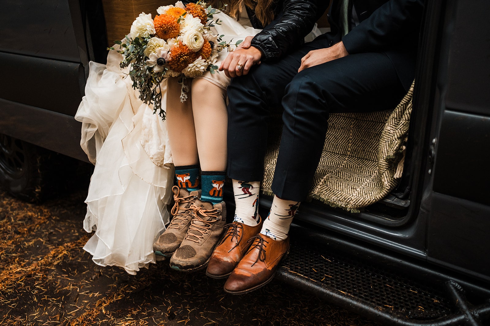 Bride and groom sit in their camper van after lacing up their hiking shoes for their fall wedding in Washington