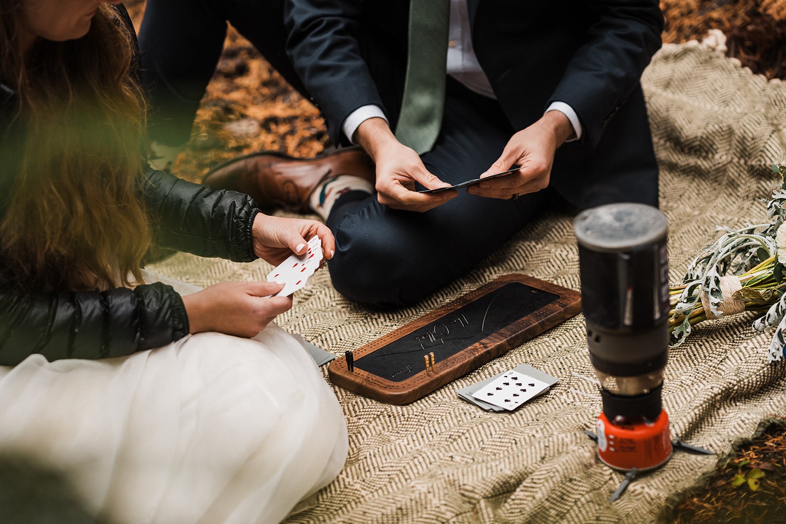 Bride and groom play cribbage on a custom cribbage board during their fall wedding in Washington