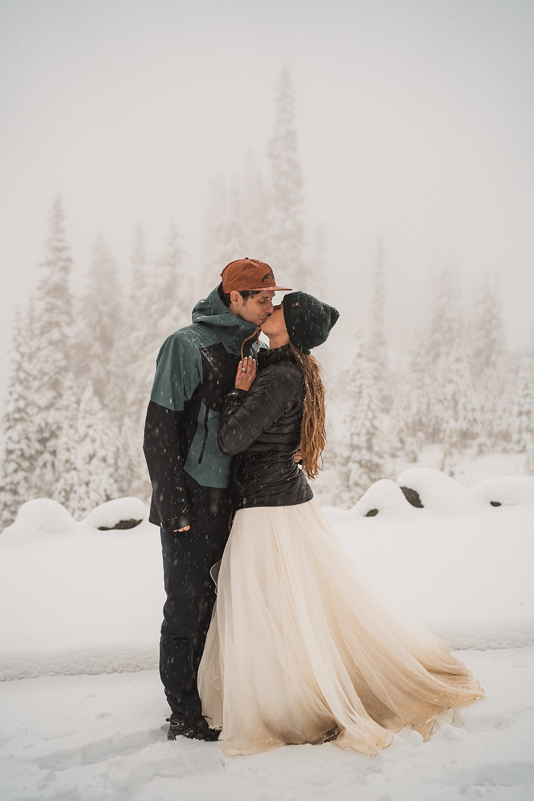 Bride and groom kiss in the snow at the end of their Washington fall elopement at Mt Rainier National Park