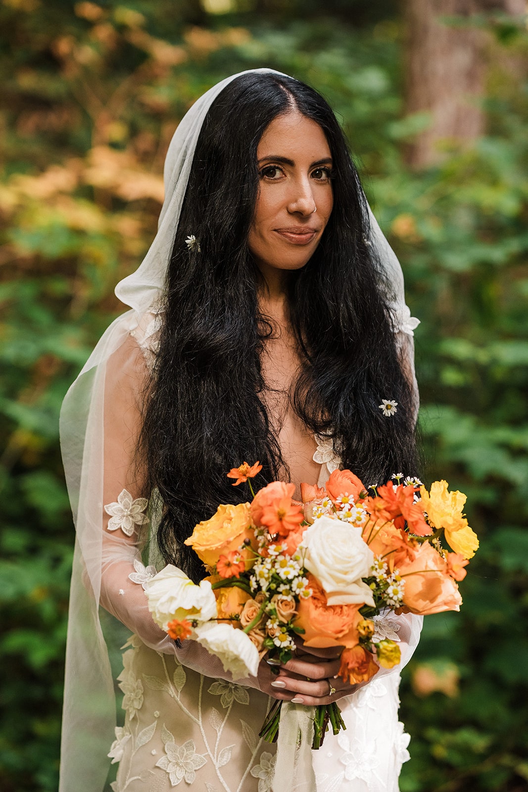 Bride holds a bouquet of orange and yellow flowers during her Mt Baker elopement 