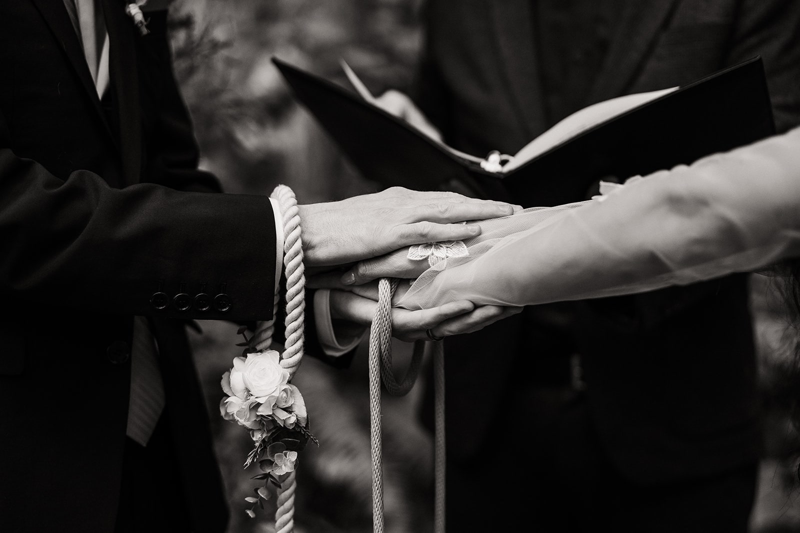 Bride and groom hold cords during their handfasting ceremony in the forest at Mt Baker