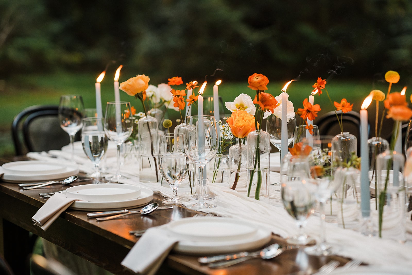 Orange and white flowers line an outdoor elopement reception table in Mt Baker