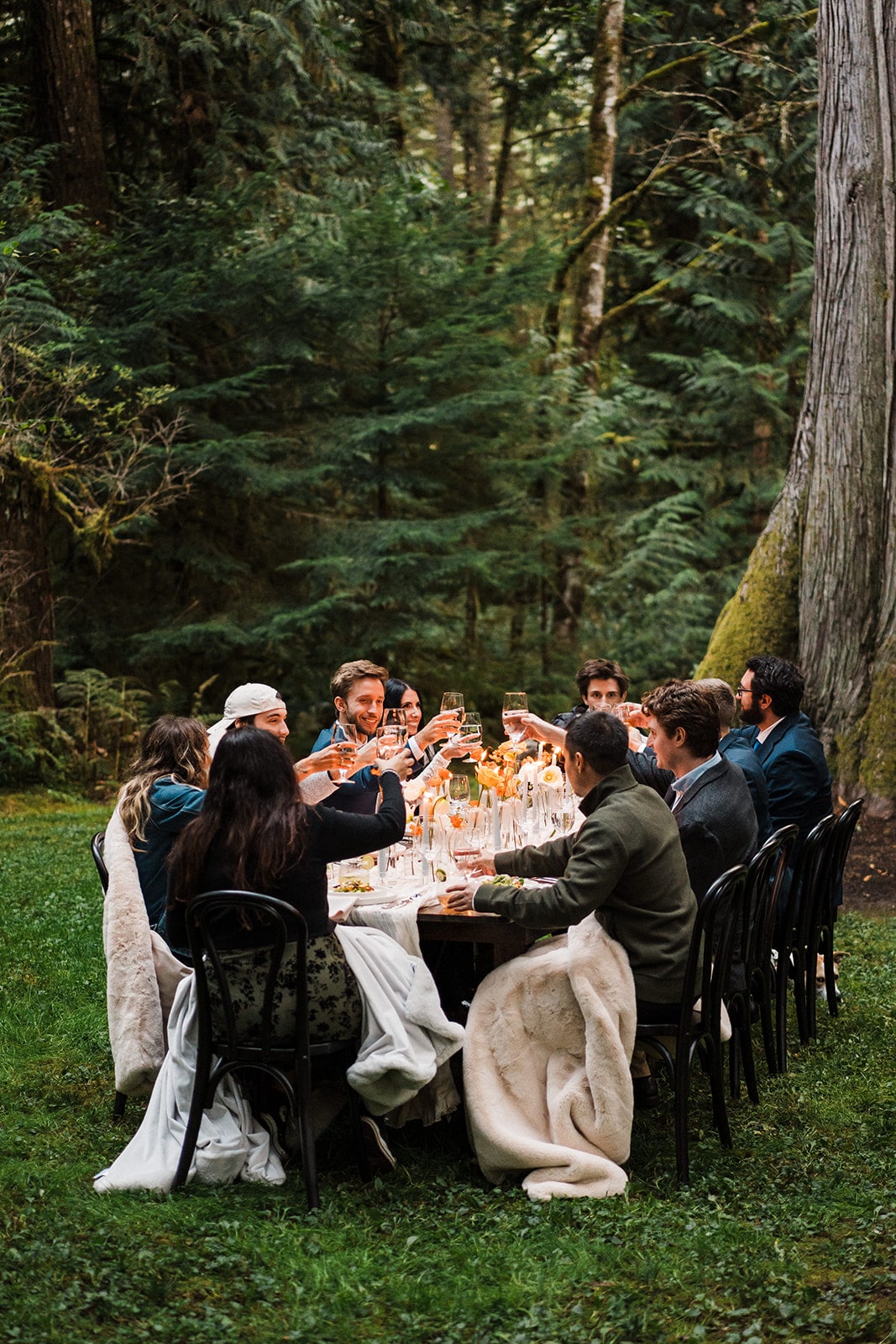 Bride and groom toast with guests at their Mt Baker elopement reception in the forest 