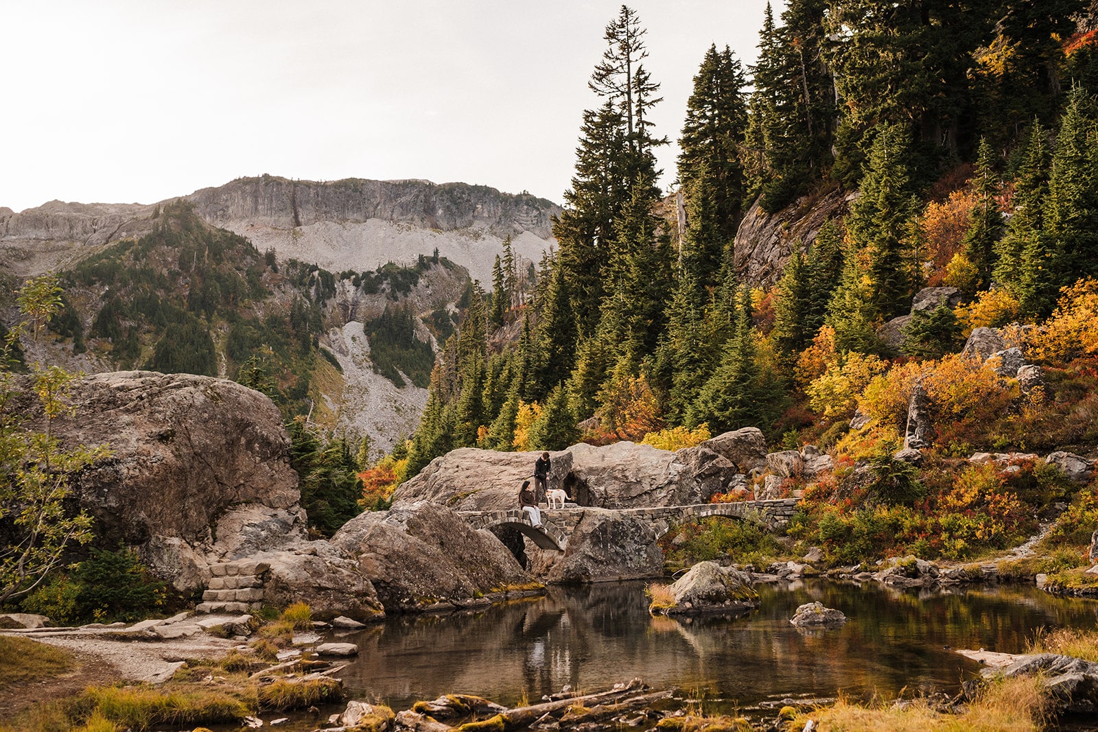 Bride and groom sit on a rock by Bagley Lakes during their two-day elopement in Mt Baker-Snoqualmie National Forest