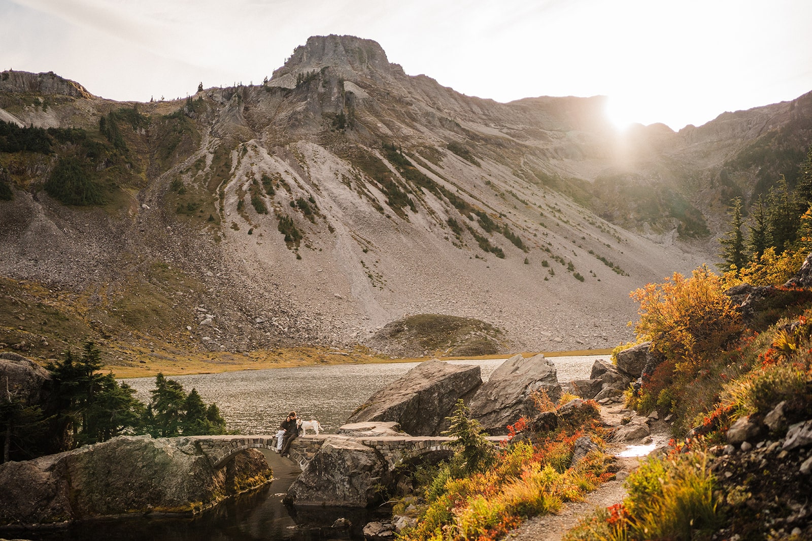 Bride and groom sit on a bridge at Bagley Lakes during their two-day elopement in Mt Baker-Snoqualmie National Forest