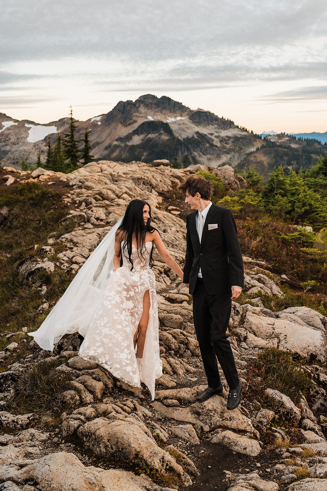 Bride and groom hold hands while walking across the mountains during their elopement at Mt Baker