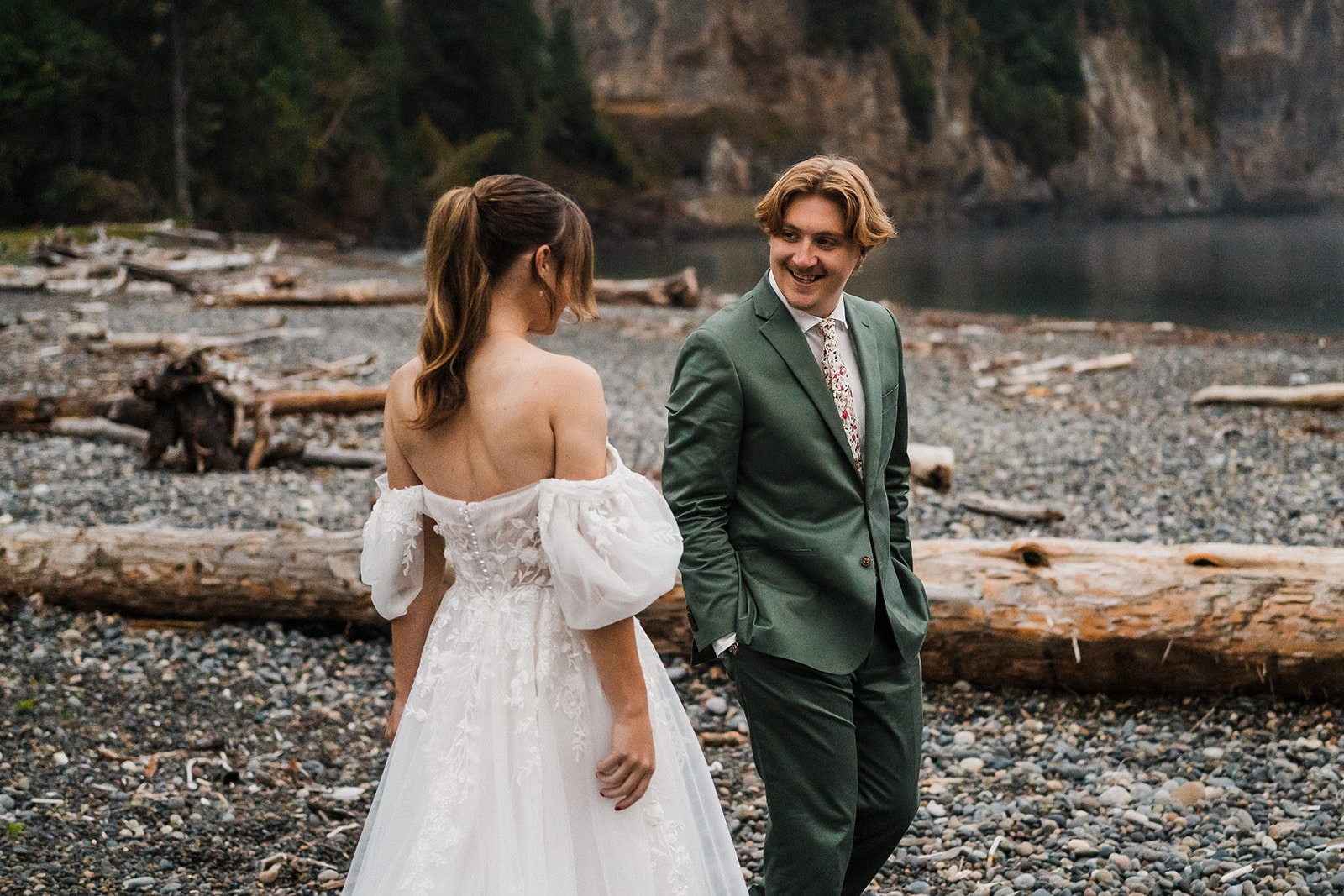 Groom turns around and smiles at bride during their elopement first look on the beach