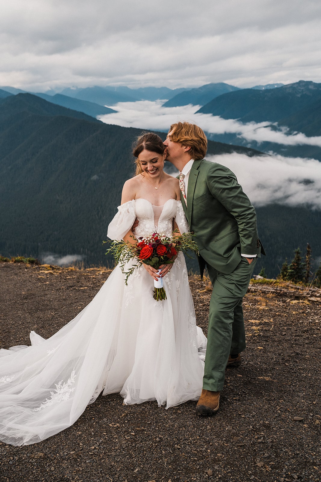 Groom kisses bride behind her ear after their national park elopement ceremony at Hurricane Ridge