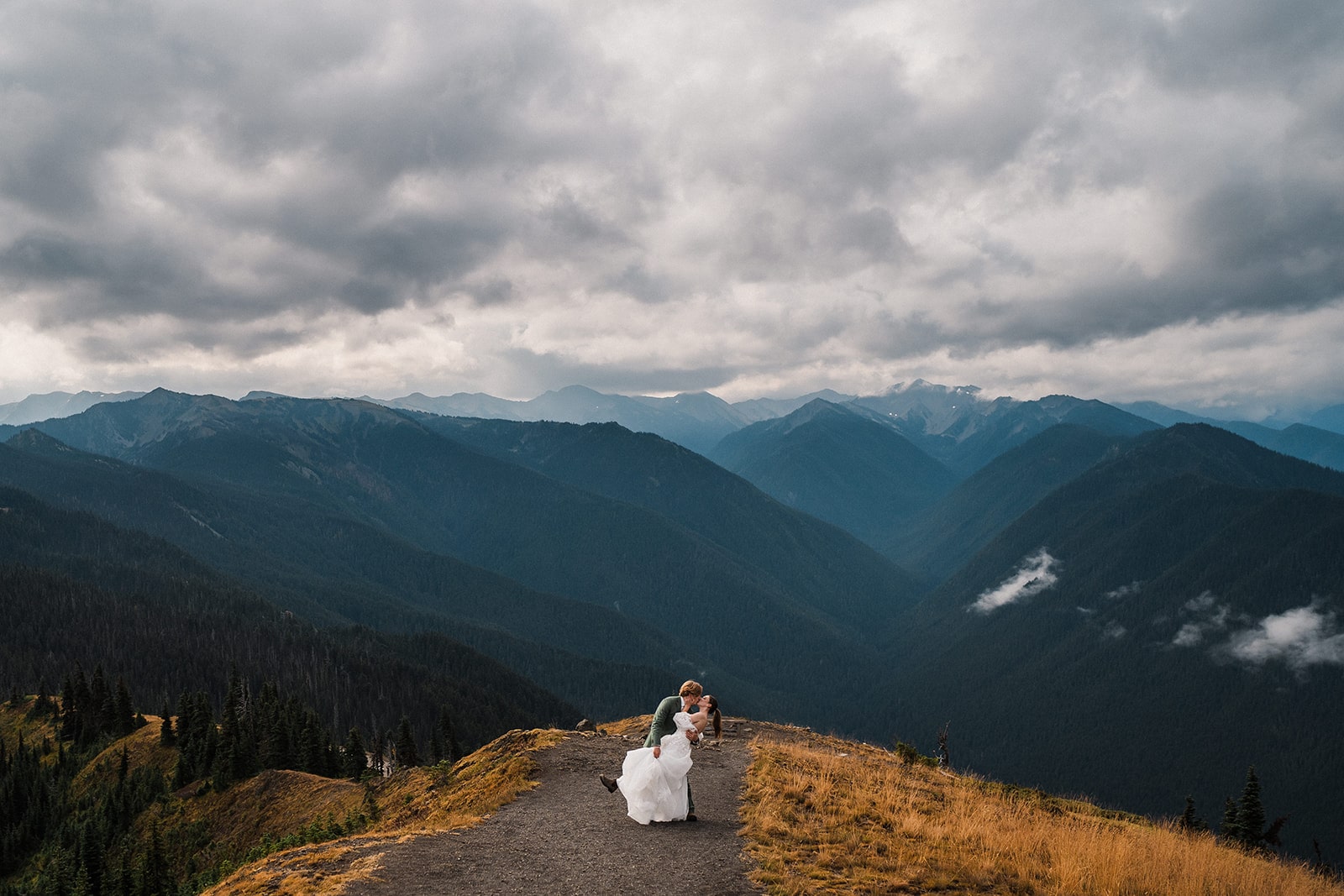 Groom dips bride for a kiss during their couple portraits at Hurricane Ridge