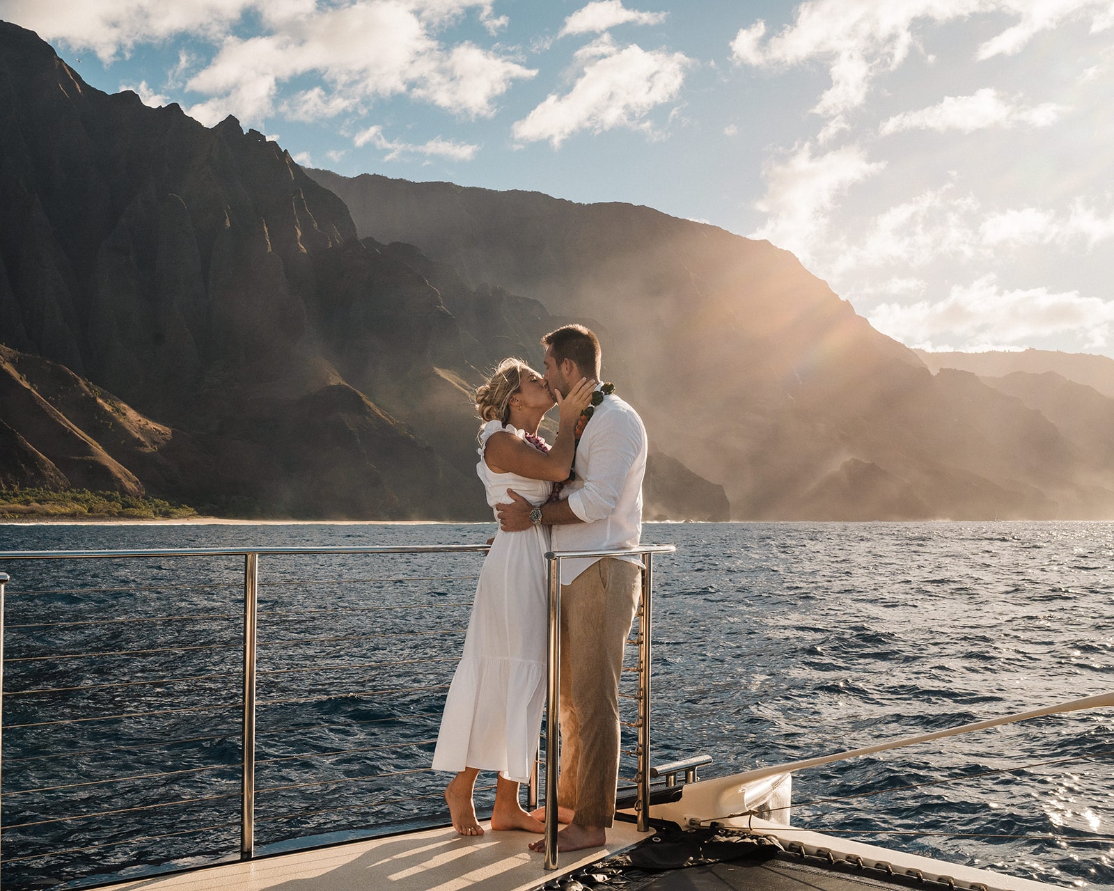 Couple kisses on the deck of a catamaran boat during a tour of the Na Pali Coast.