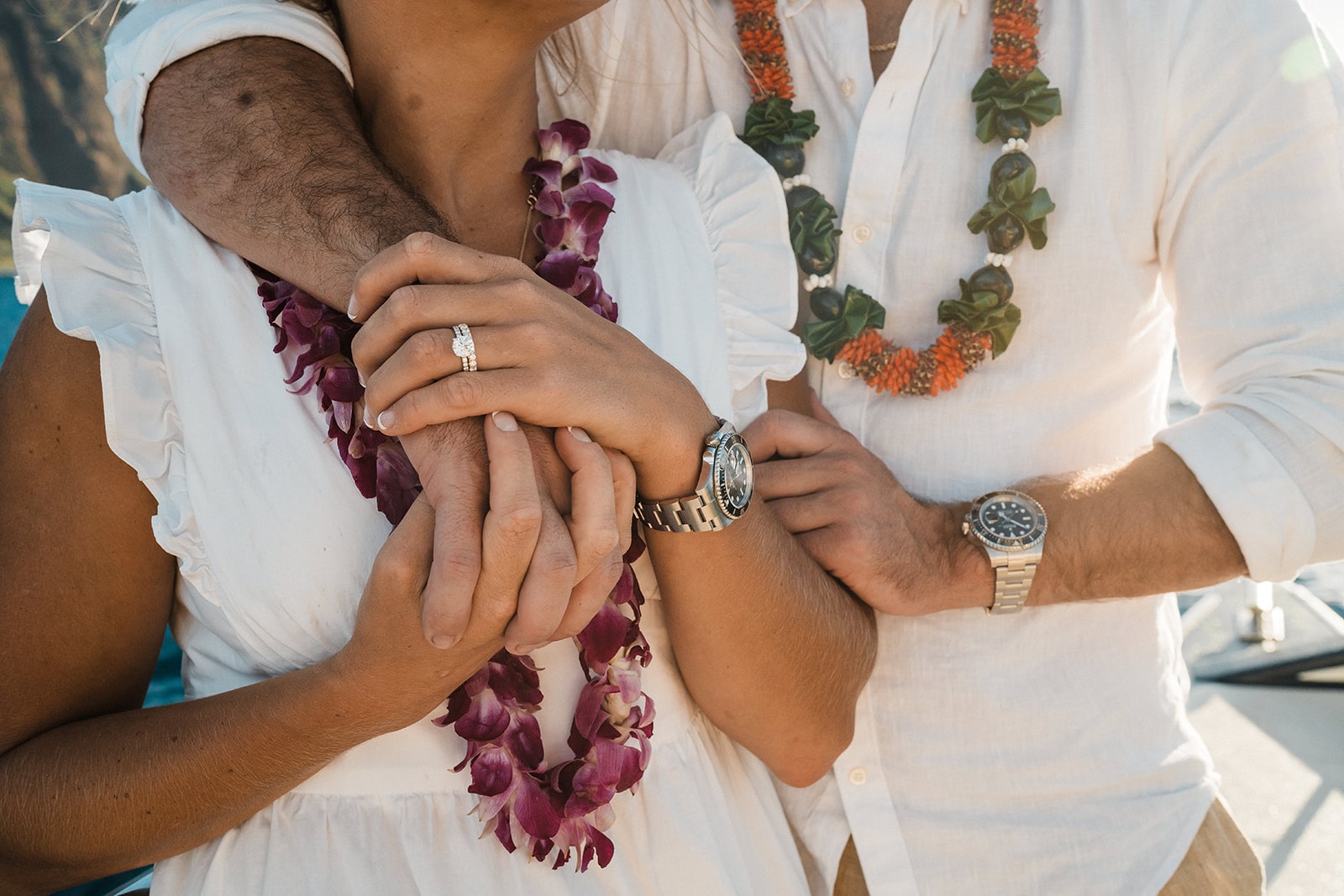 Couple wearing leis and matching watches during their boat tour of the Na Pali Coast.