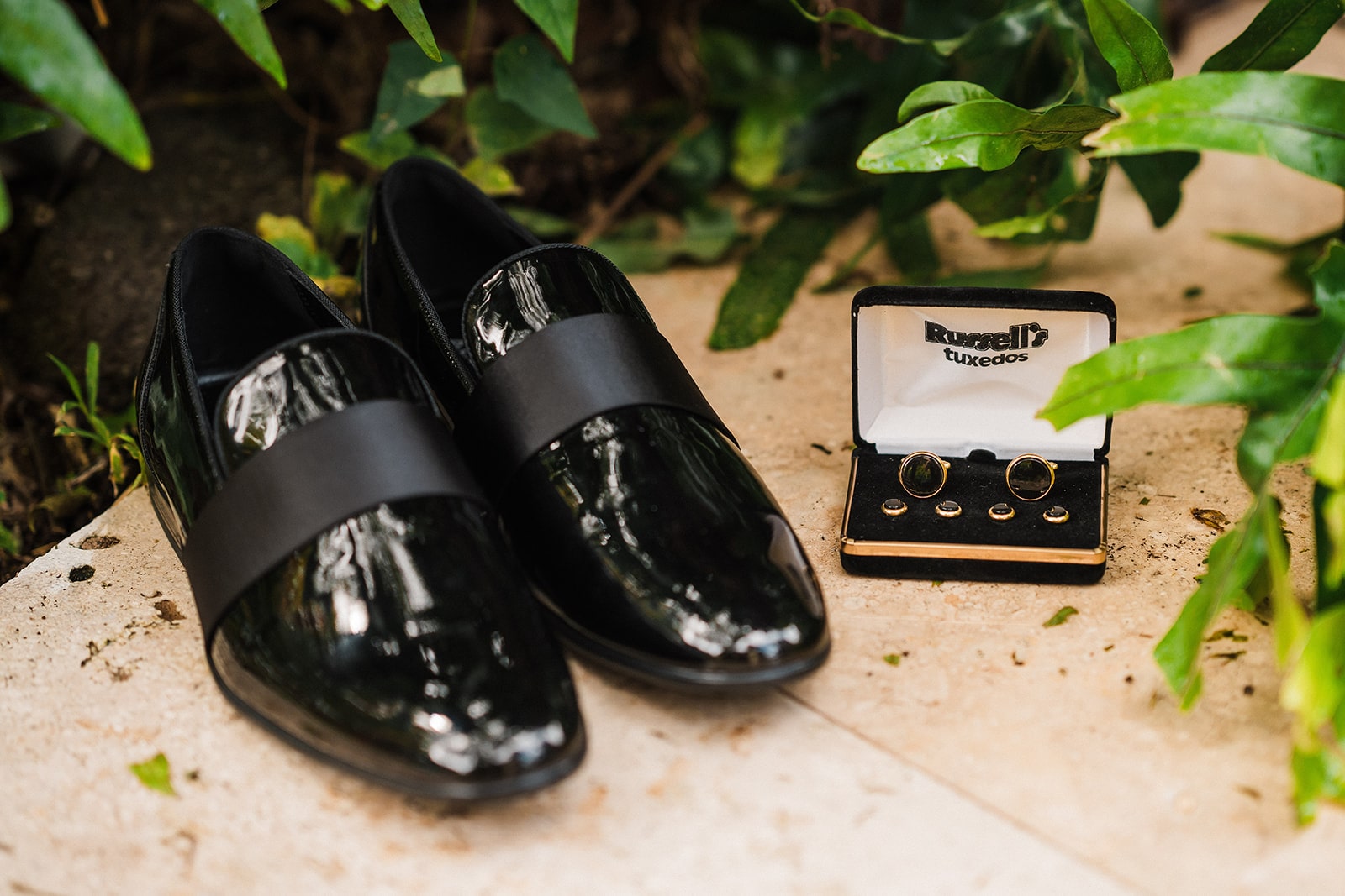 Black patent leather dress shoes and black cuff links.