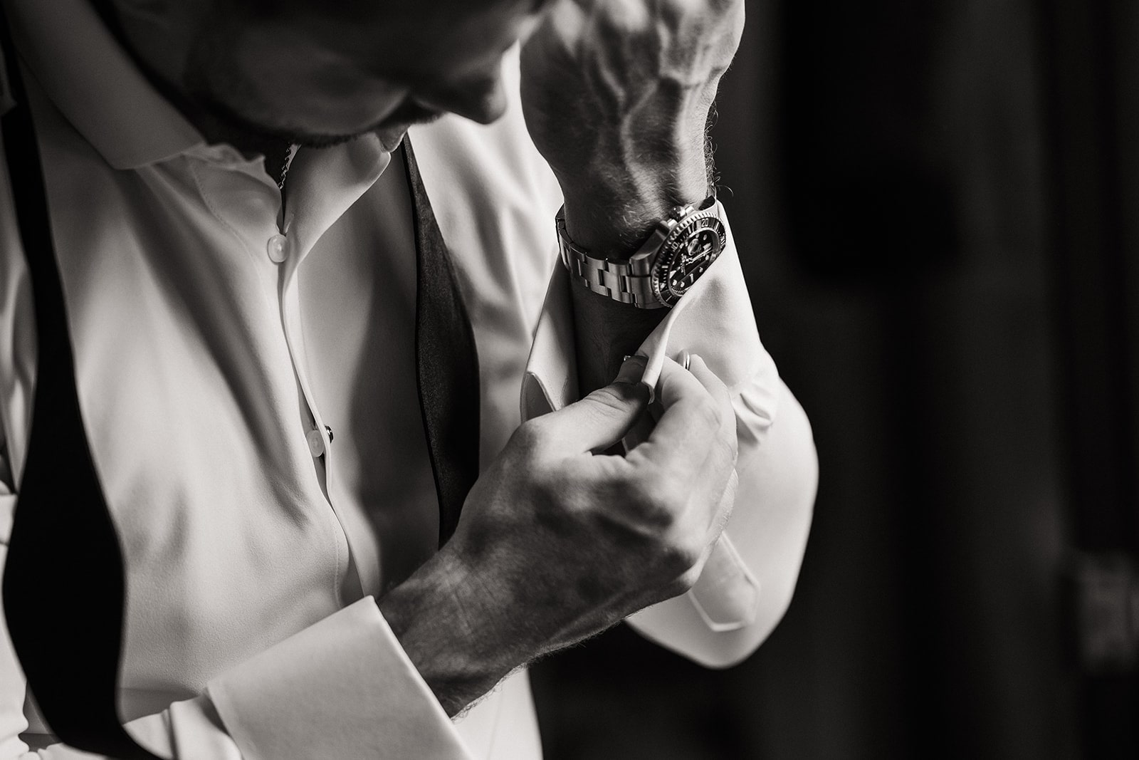 Groom puts on cuff links while getting ready for his Kauai wedding.