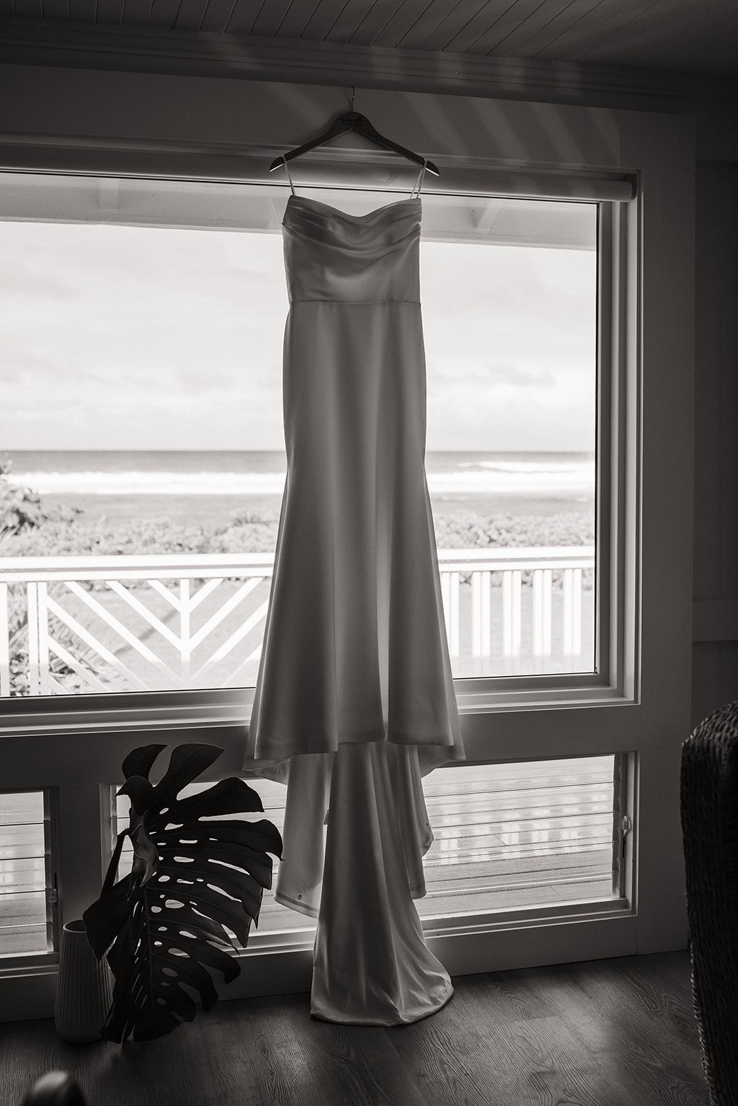 White wedding dress hanging from a window sill at an Airbnb in Kauai.