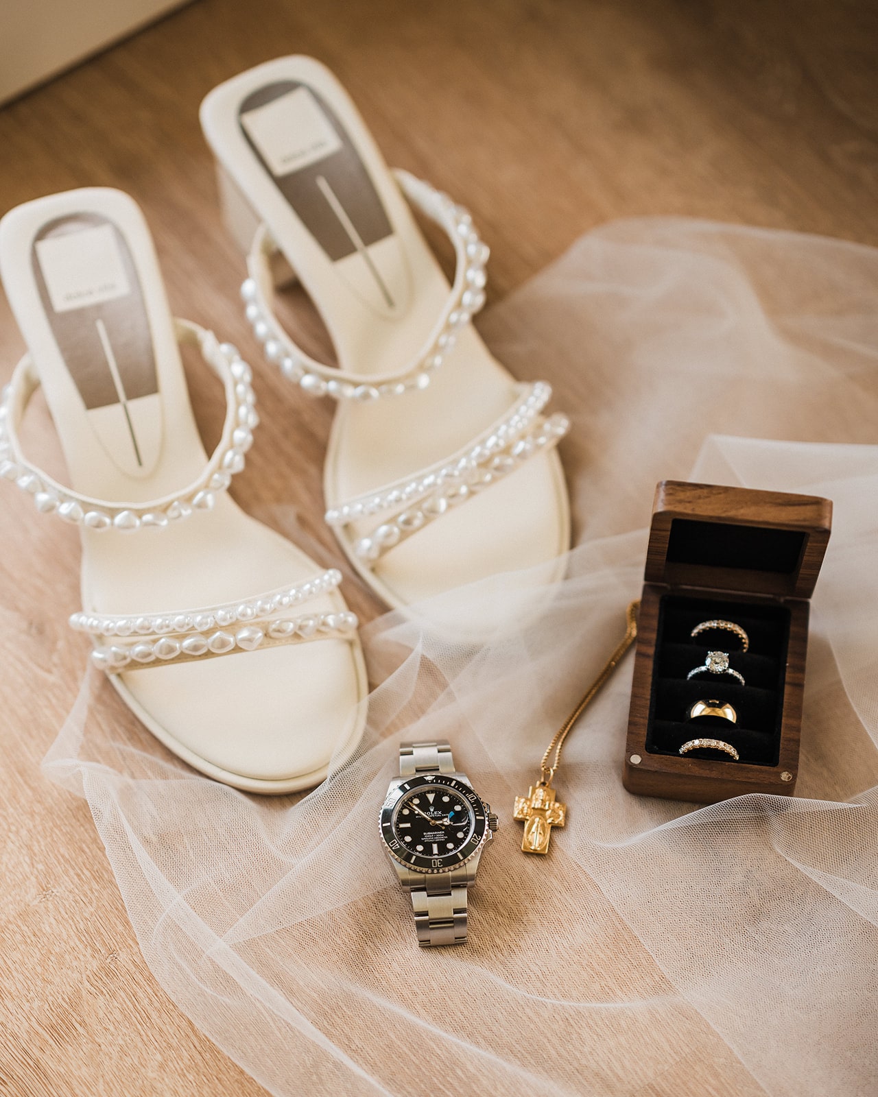 White pearl block heels with gold and diamond wedding bands.