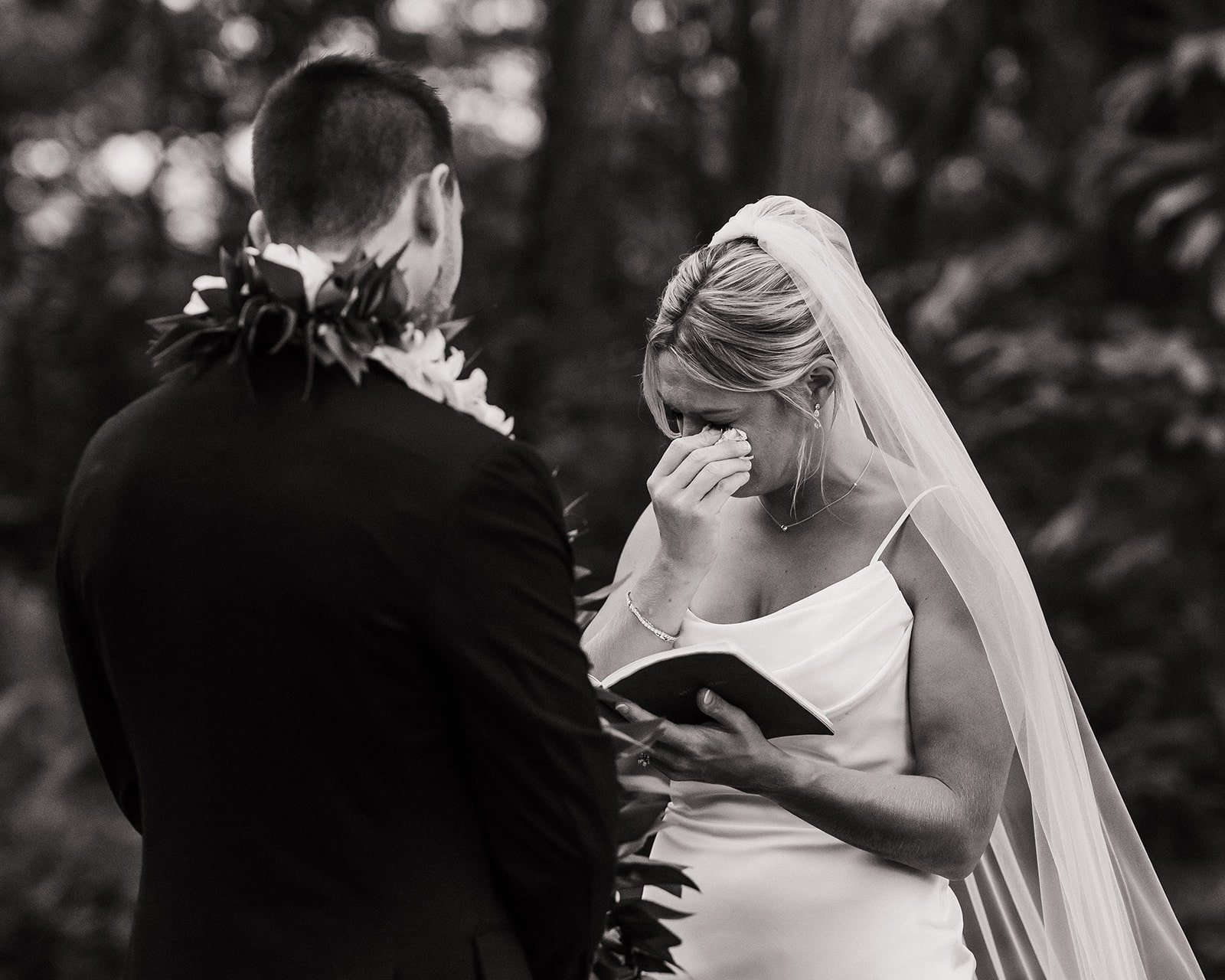 Bride wipes her tears while reading private vows to groom during their three-day wedding weekend in Kauai.