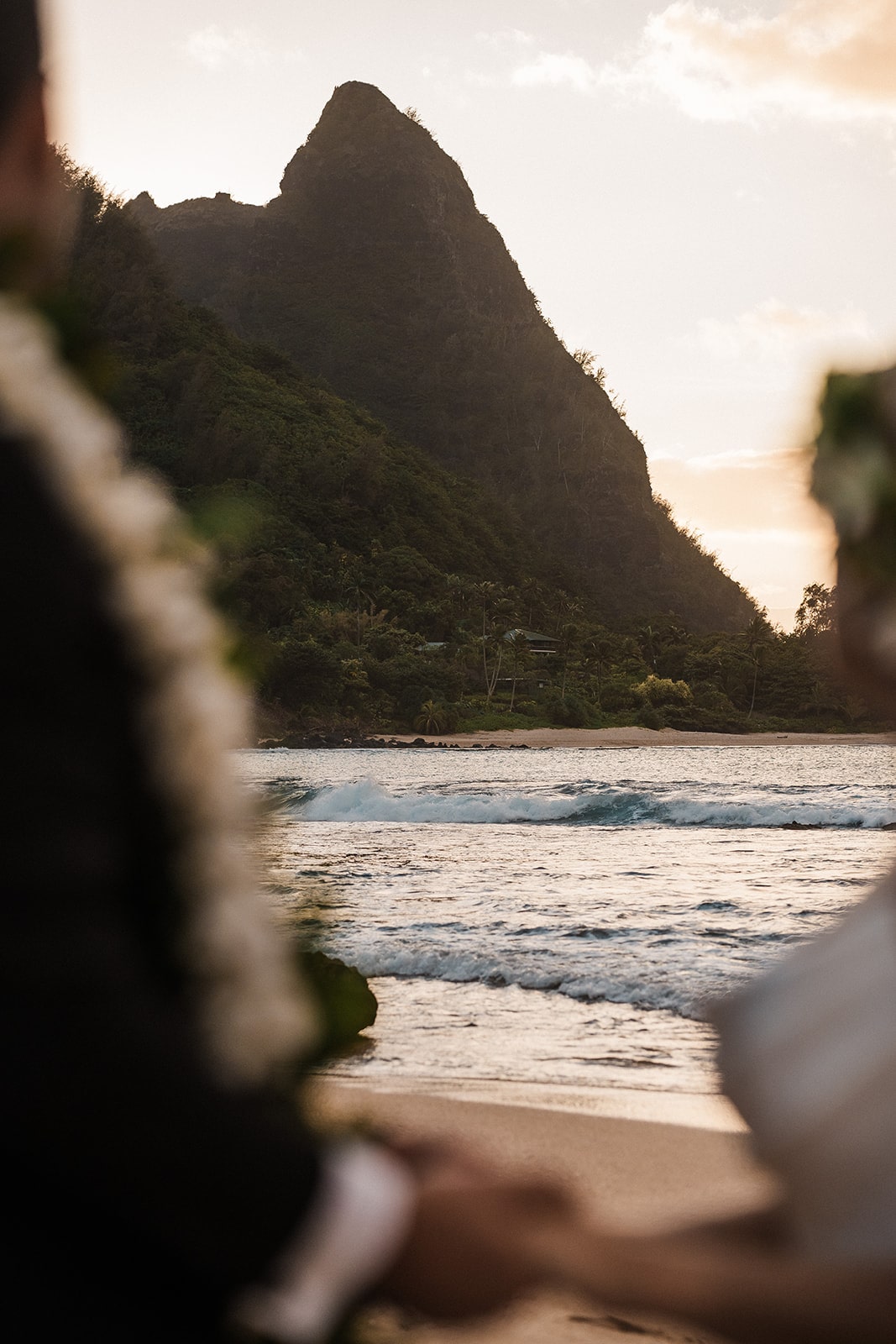 Bride and groom hold hands on the beach in North Shore at their Kauai wedding.