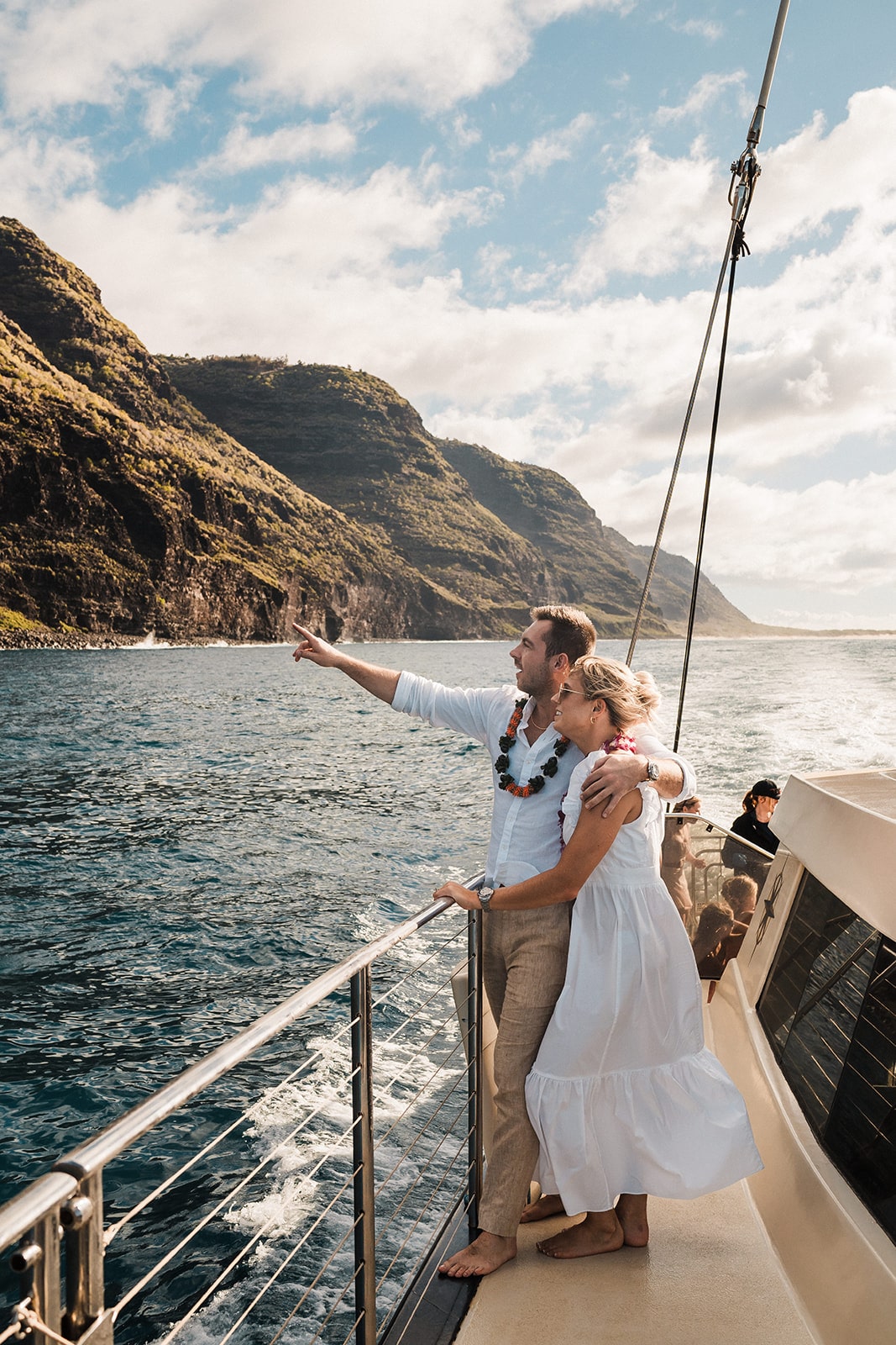 Bride and groom look out at the coast during their Kauai wedding weekend.
