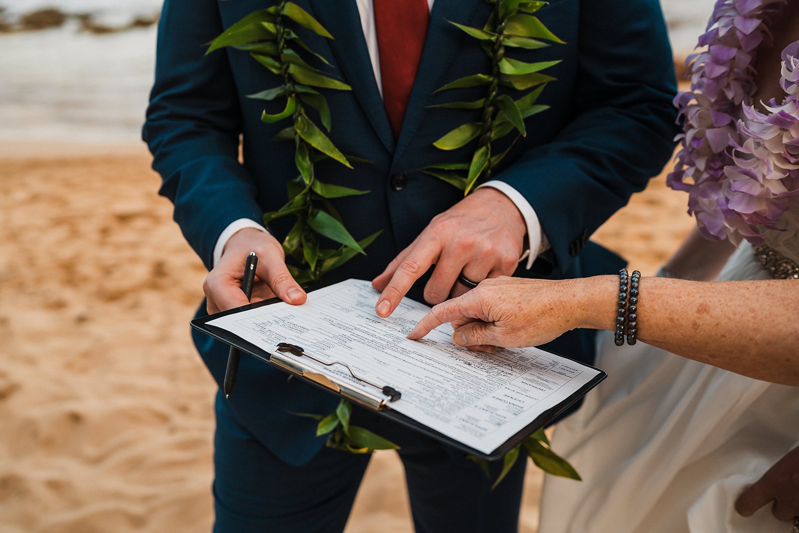 Bride and groom sign their Hawaii marriage license after eloping in Kauai.