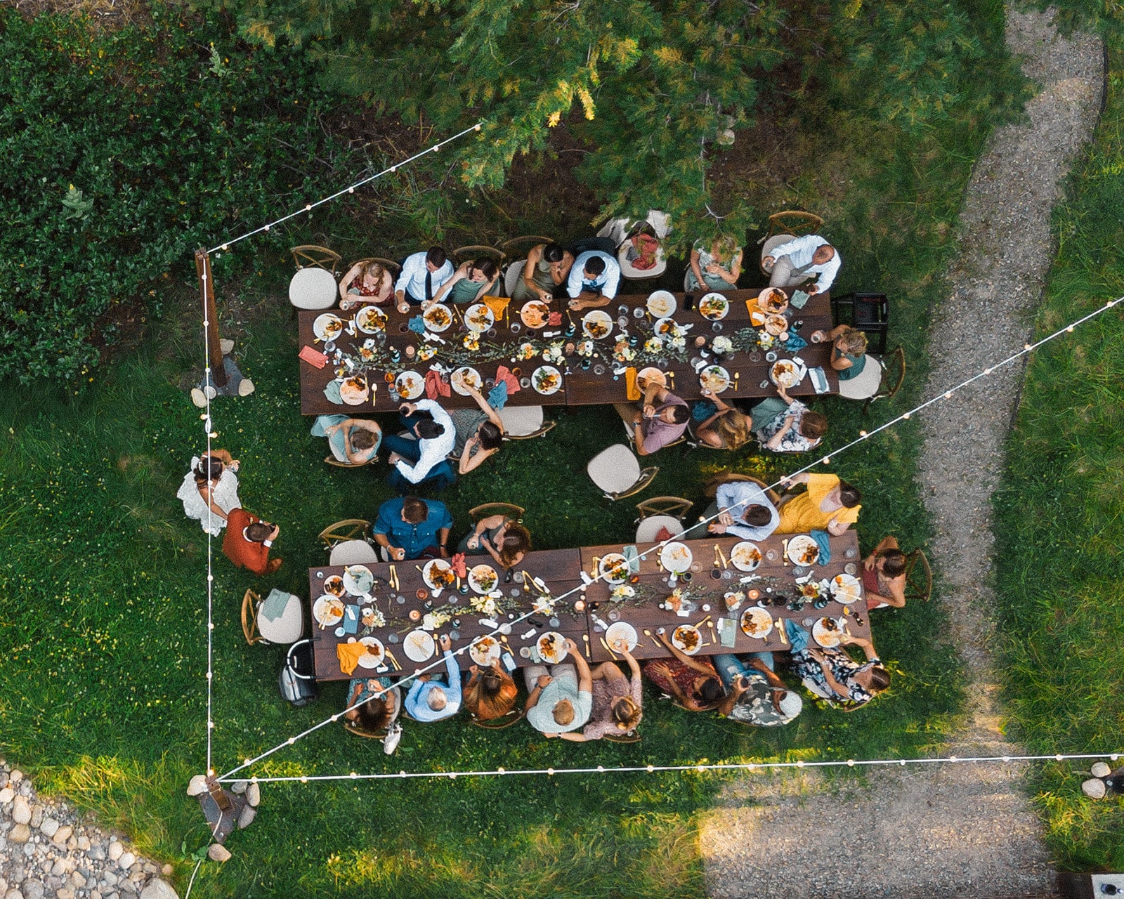 Guests sit around an outdoor wedding reception dinner table at a wedding weekend in the North Cascades.