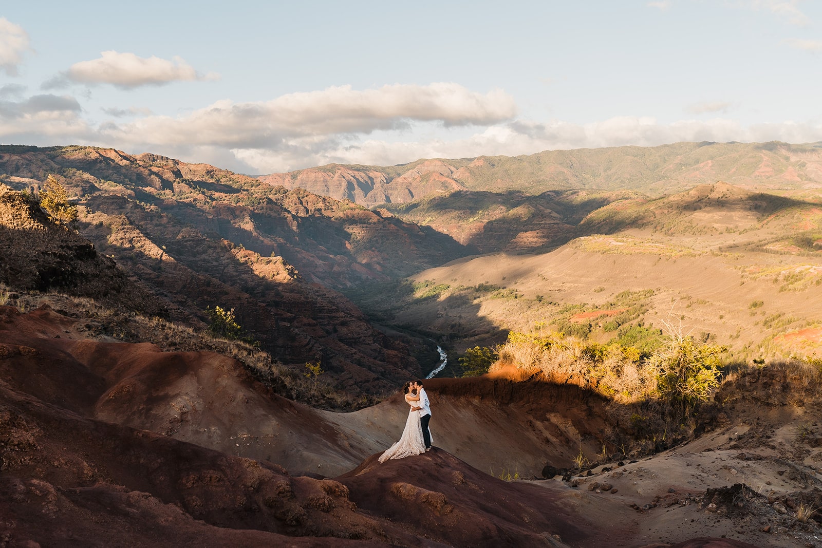 Bride and groom kiss during sunset at Waimea Canyon, one of the best Kauai elopement locations.