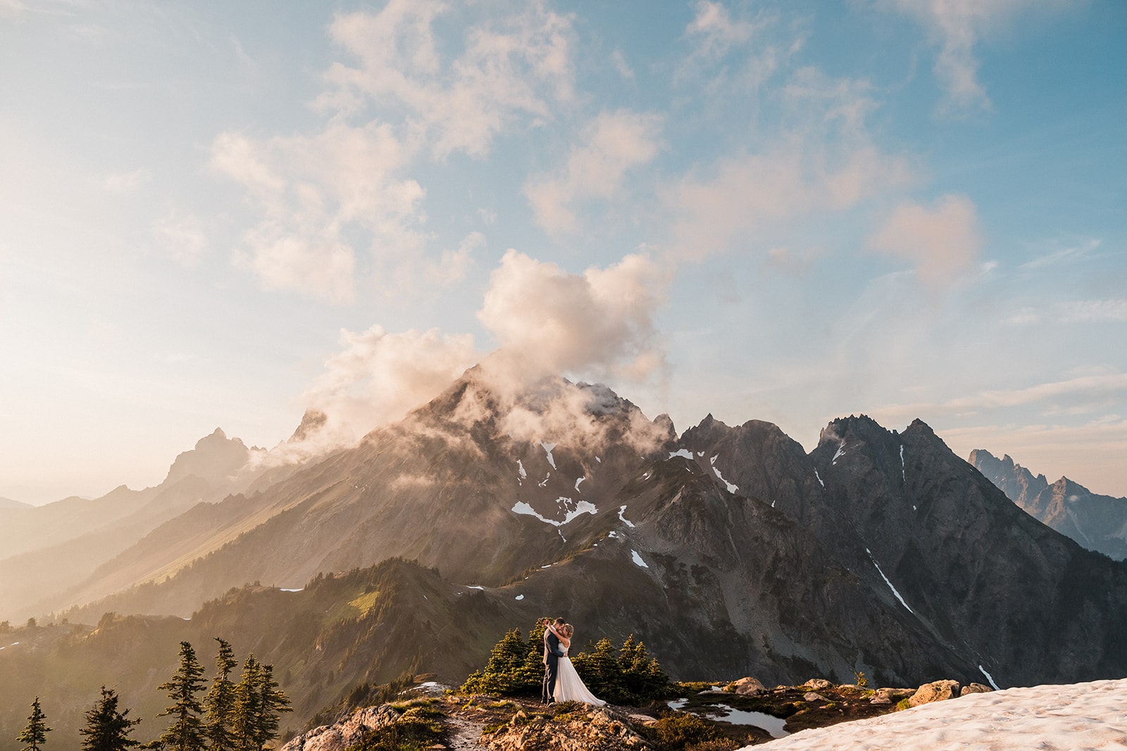 Bride and groom kiss on a mountain trail in the North Cascades during their elopement in Washington.