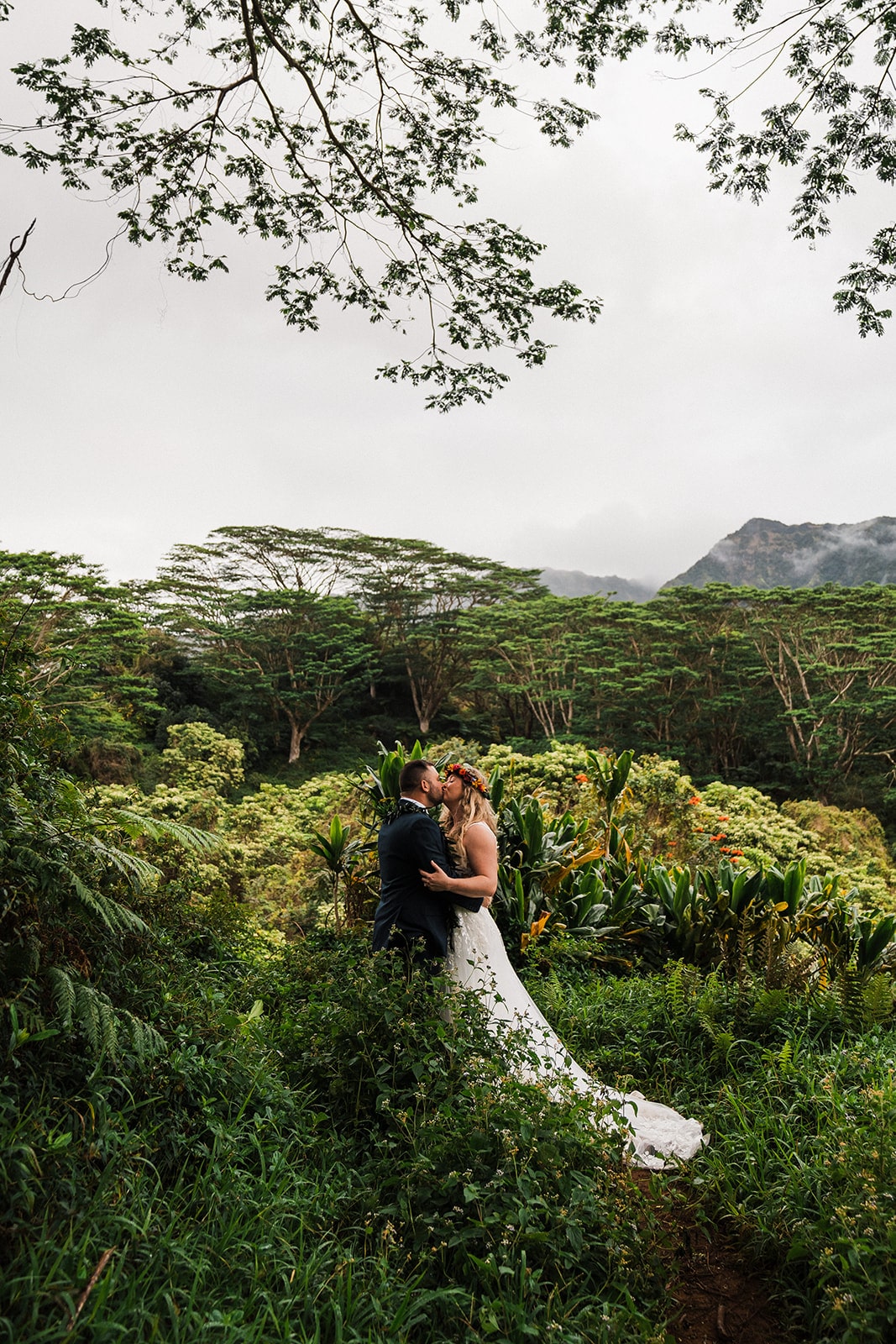 Bride and groom kiss in the Kauai rainforest during their Kauai Hawaii activities and adventure elopement. 