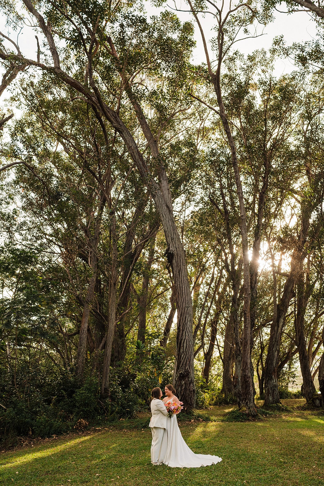 Brides hug at Common Ground, one of the best places to get married in Kauai.