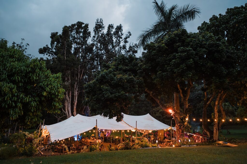 Sunset wedding reception dinner under a white canpoy tent at Common Ground.