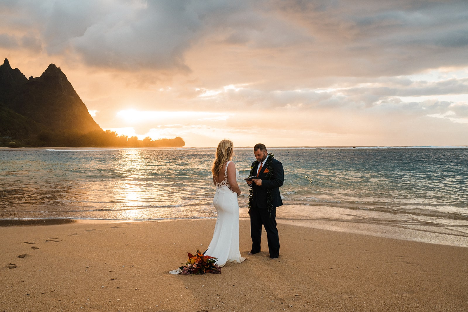 Bride and groom exchange private vows on a beach during their Kauai activities and elopement.