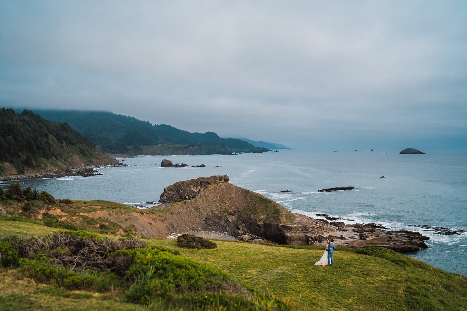Bride and groom hug on the Oregon Coast at sunset during their elopement.