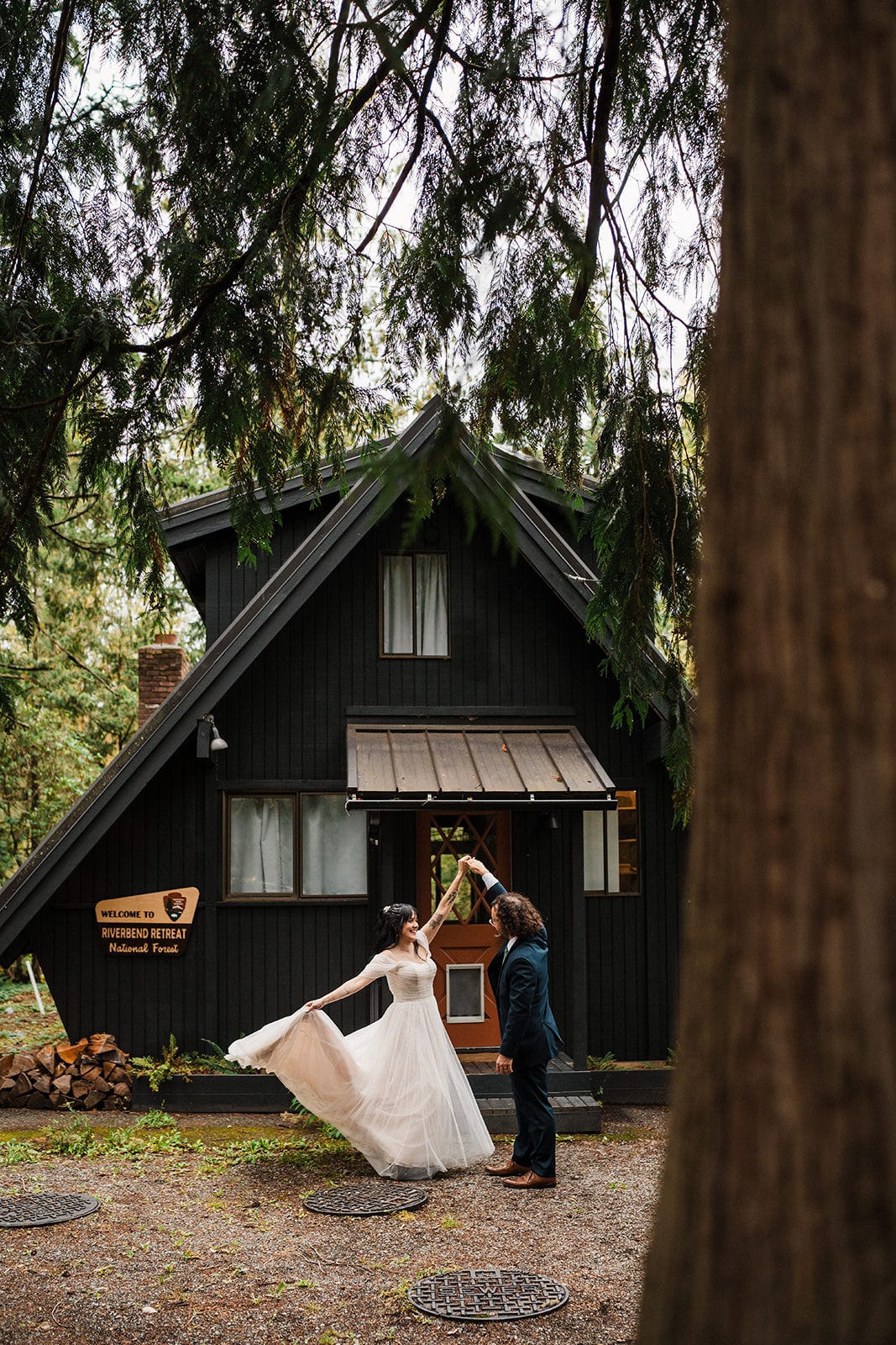 Bride and groom dance in the forest in front of their Airbnb cabin. 