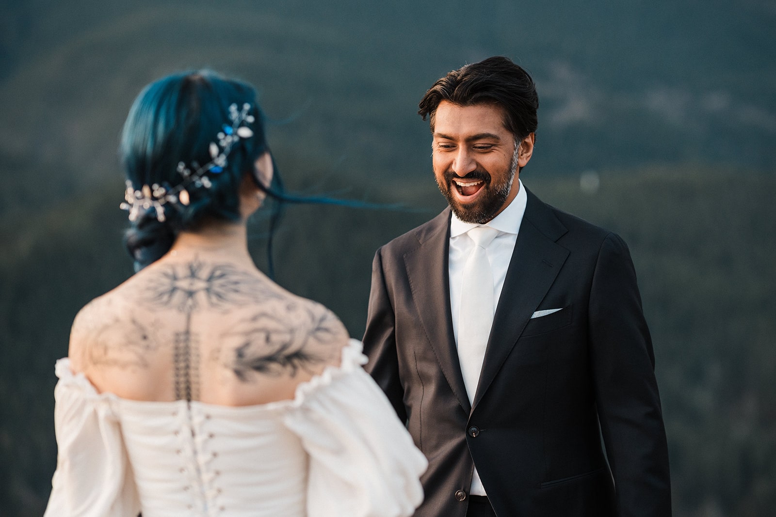 Groom smiles during elopement first look with bride. 