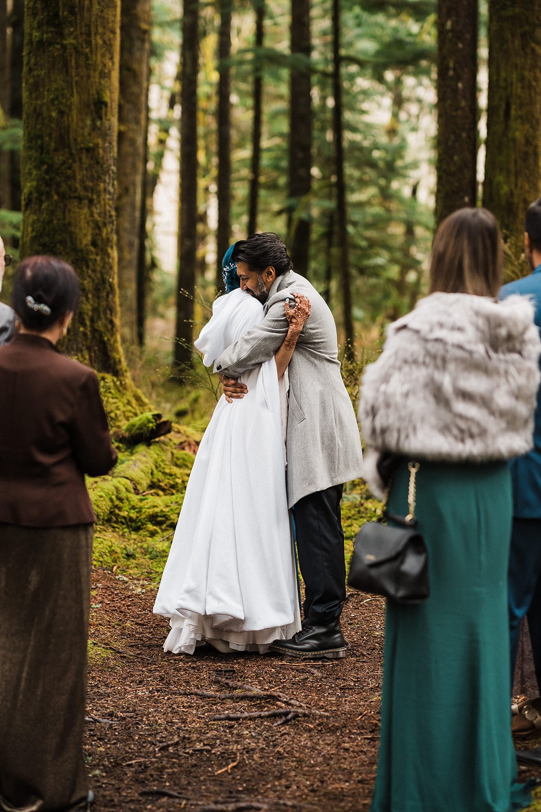 Bride and groom hug during their forest wedding ceremony in Snoqualmie, Washington.