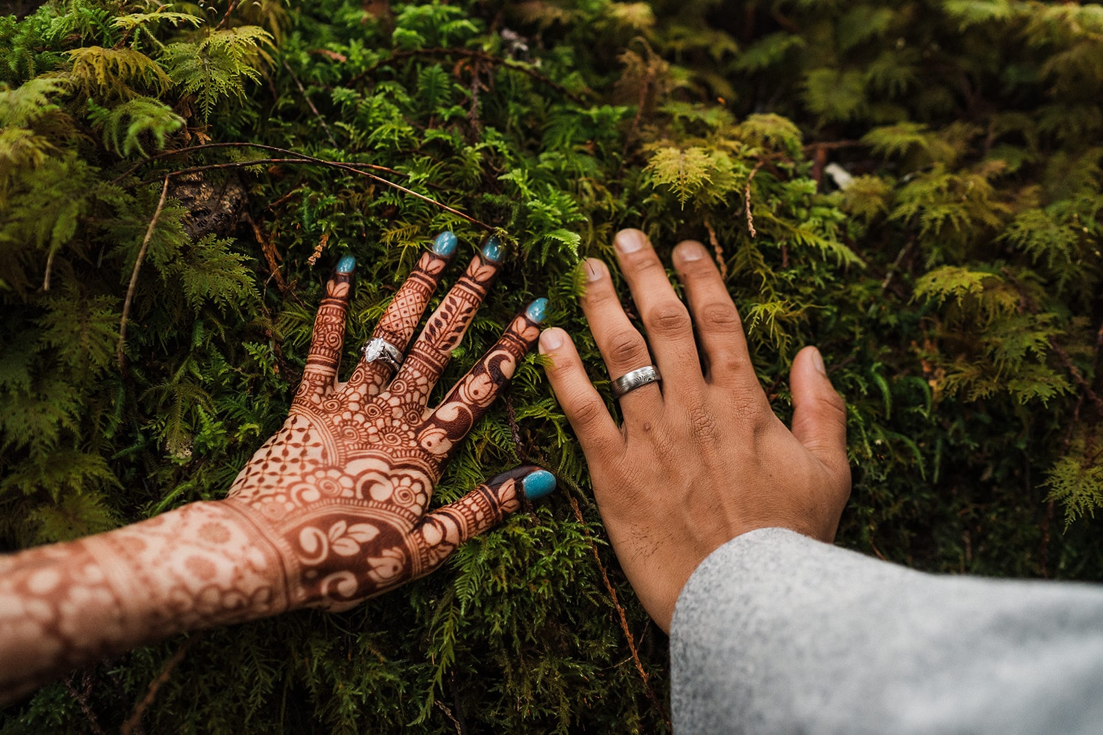 Bride and groom reach out to touch the moss during their unique elopement in Snoqualmie, Washington. 