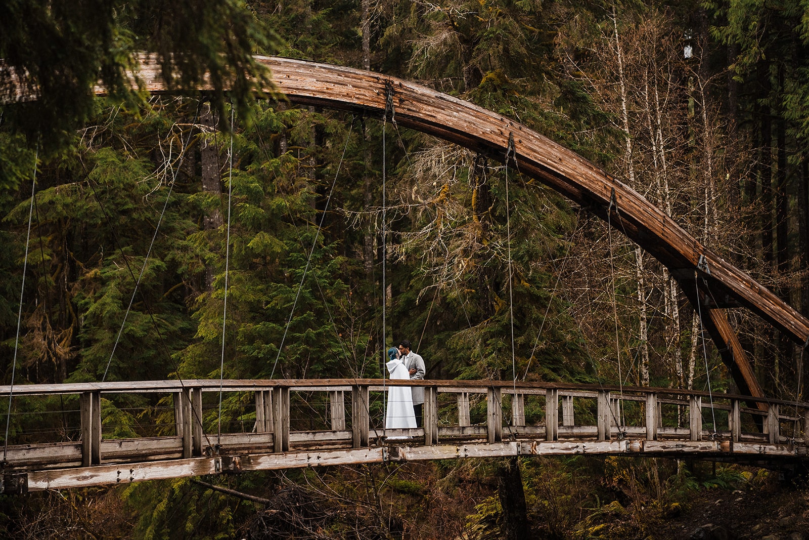 Bride and groom kiss on a wood bridge in Snoqualmie, Washington. 