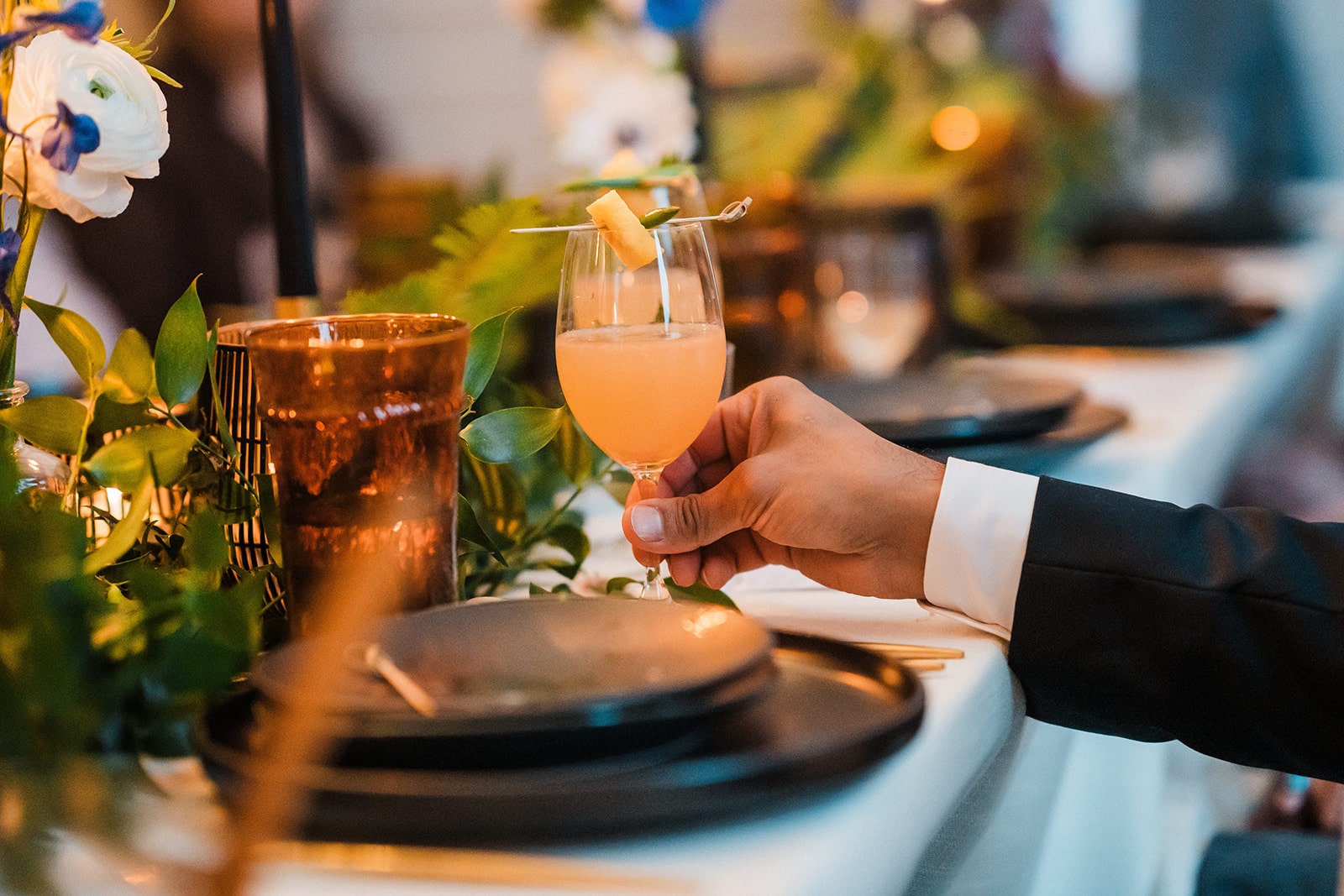 Groom lifts a custom mocktail during his elopement dinner reception. 