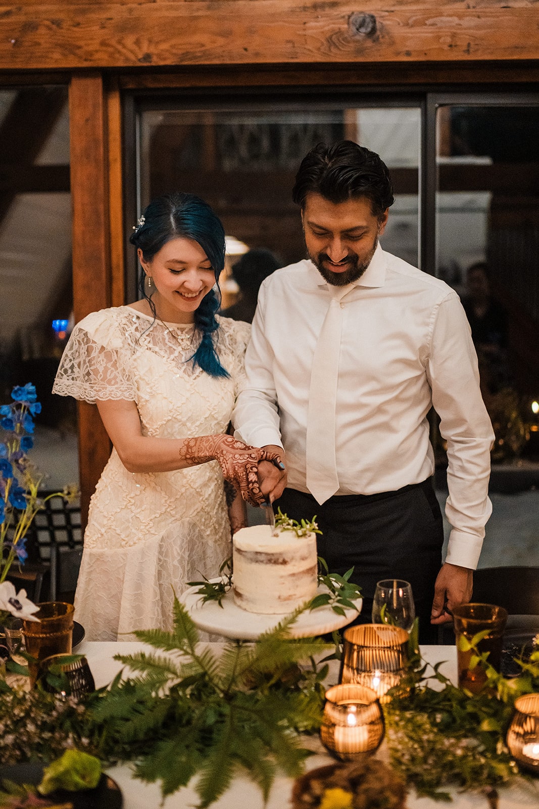 Bride and groom cut a white cake during their unique elopement reception dinner. 