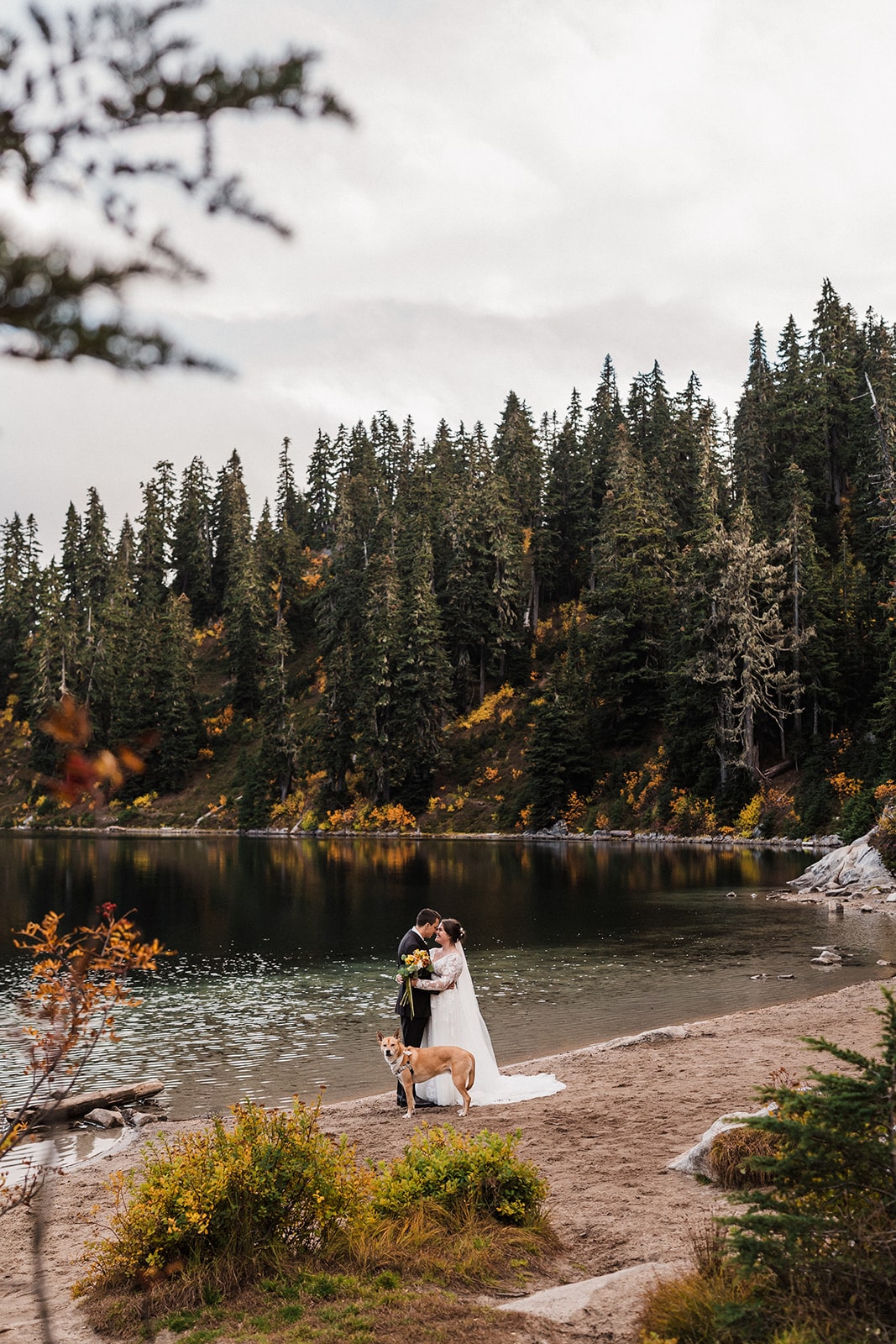 Bride and groom hug next to an alpine lake in Lake Wenatchee State Park - an outdoor wedding venue in Washington